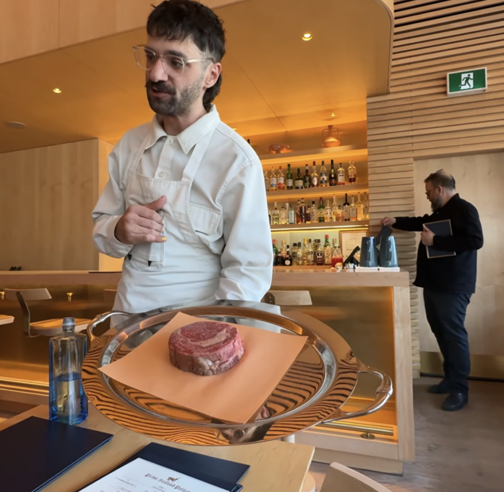 Chef presenting the main course meat option at Matty Matheson's restaurant Prime Seafood Palace